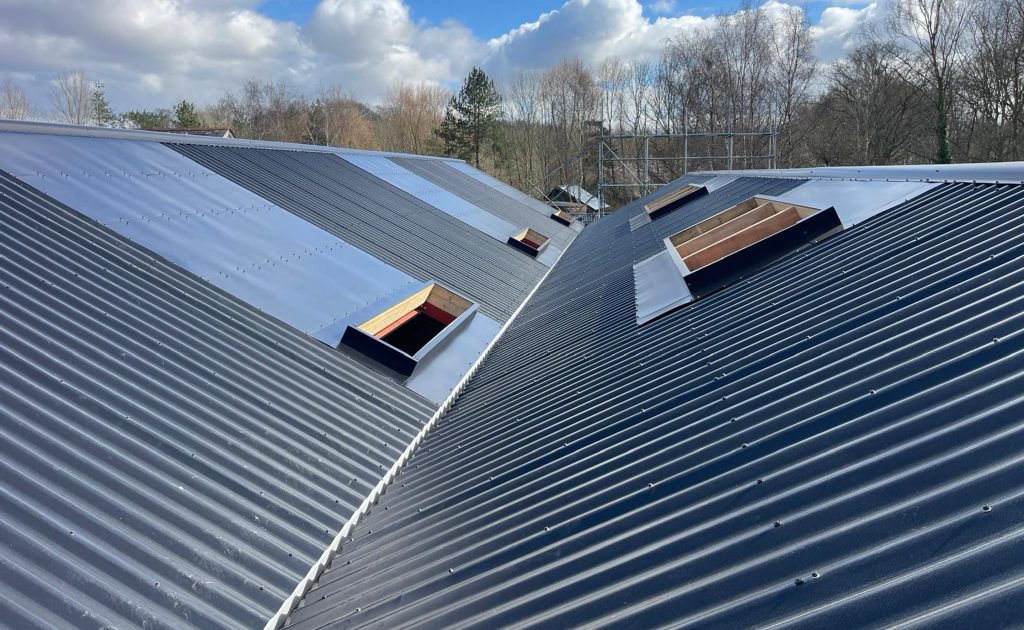Kingspan insulated valley gutters. KS1000SRW insulated roof panels. Bespoke flashings for roof penetrations.